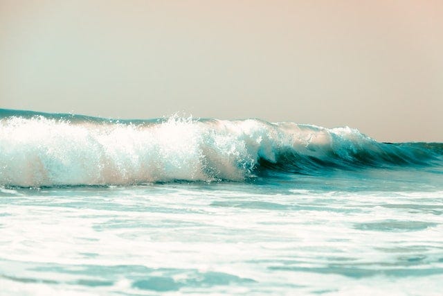 Aqua ocean wave breaking on the beach