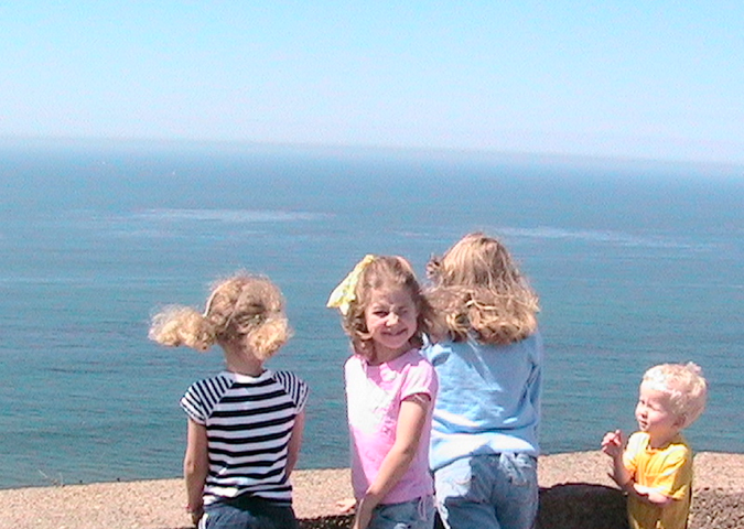 Four young children looking at an ocean view