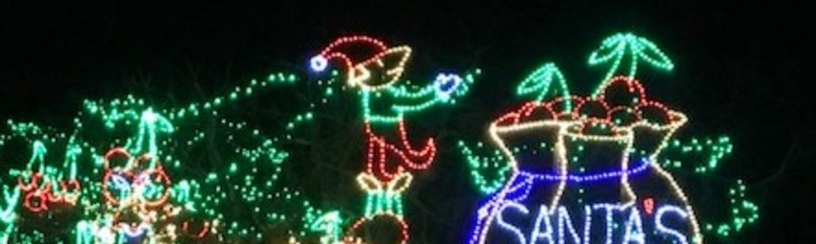 A lighting display with elves putting cherries into Santa’s bag