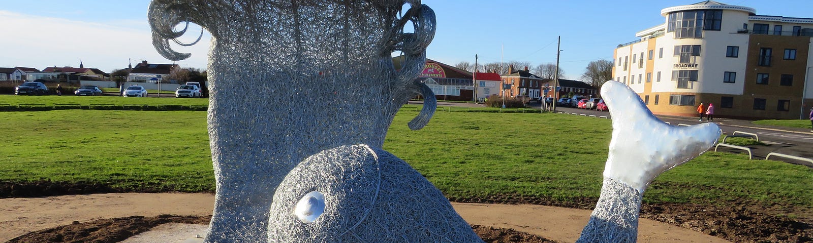 Woven wire sculpture of fish and pouncing wave