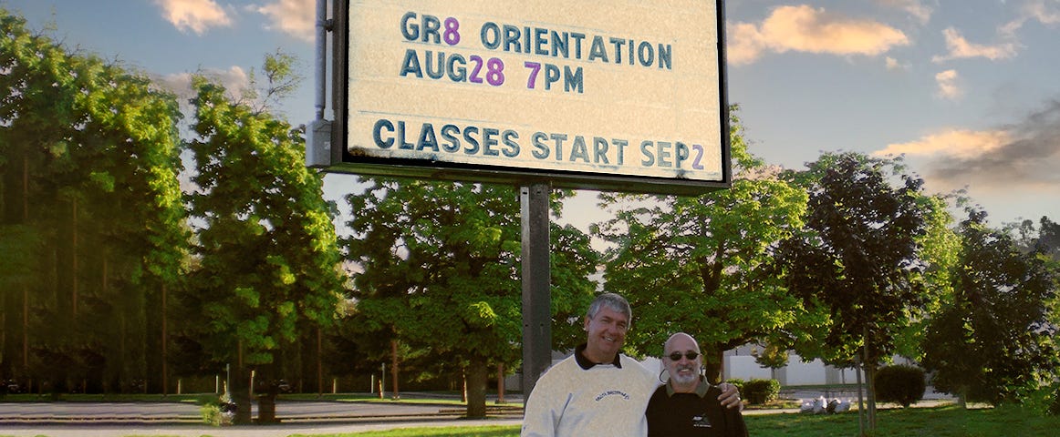 two guys in front of a high school billboard