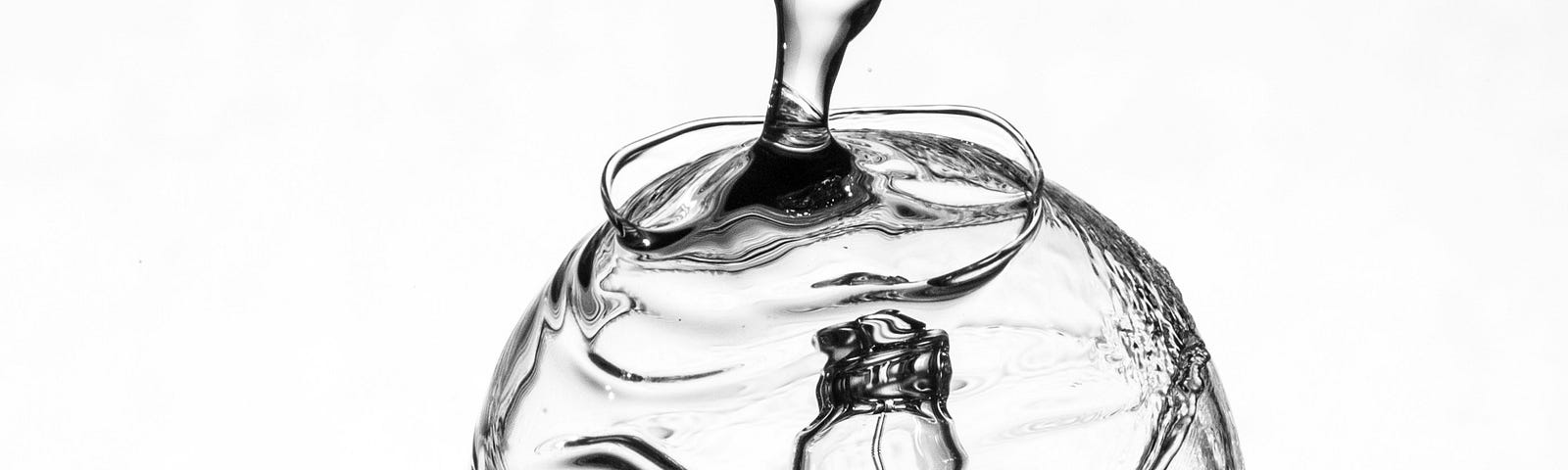 a black and white photo of a lightbulb flowing up into water, dripping down