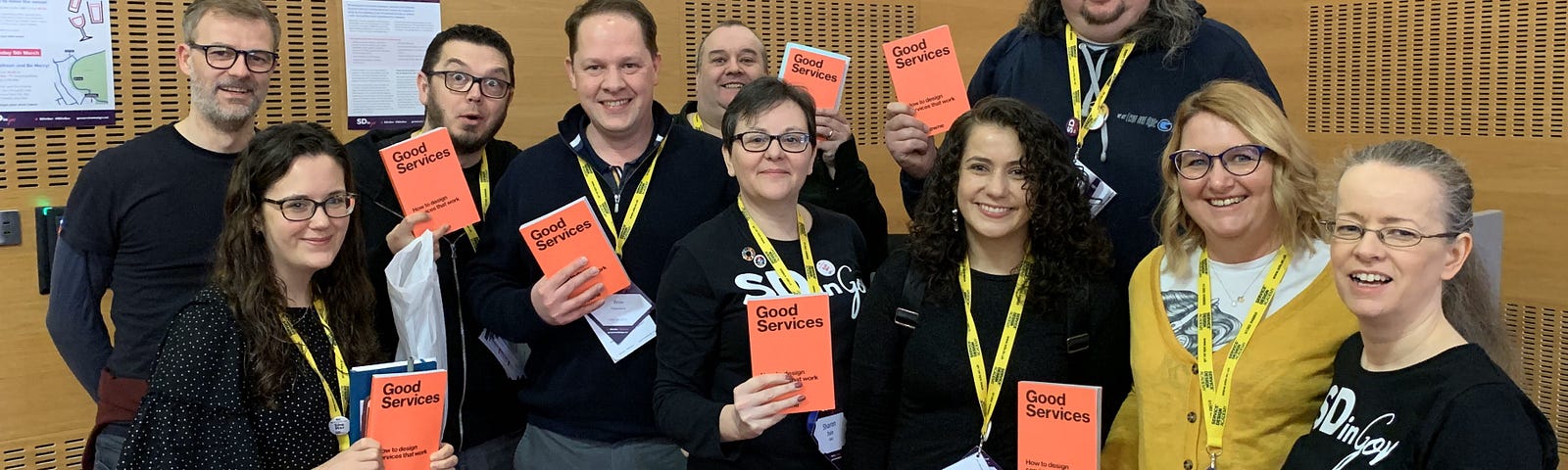 A crowd of people at the Service Design in Government conference show off their new books