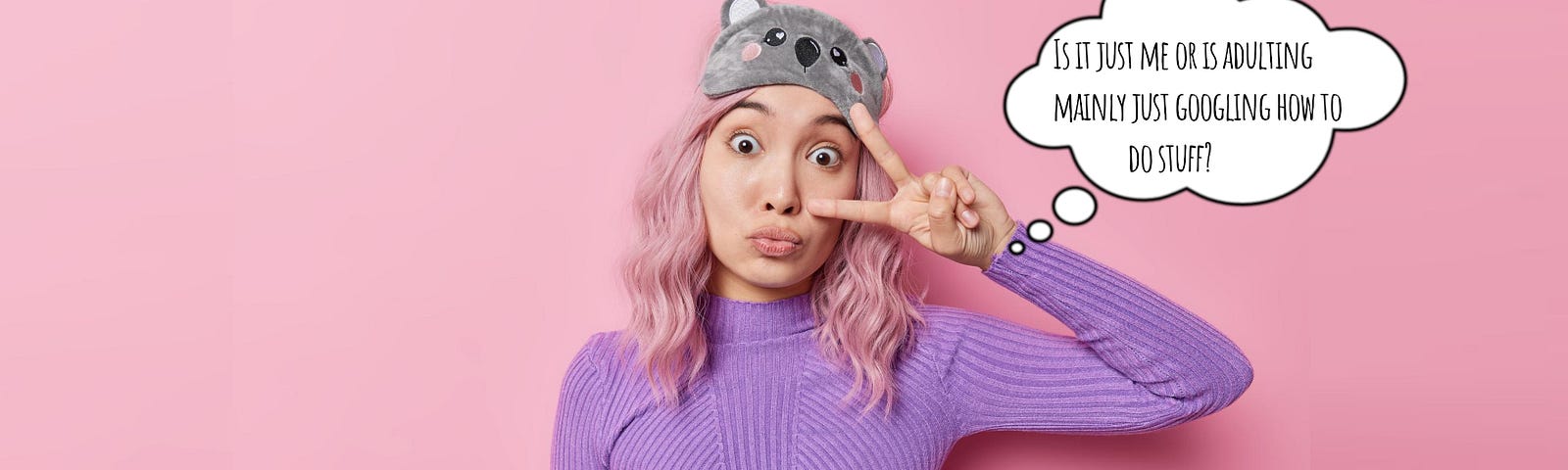 Young woman with pink hair making a silly face and a cartoon koala sleep mask on her head — throwing a peace sign