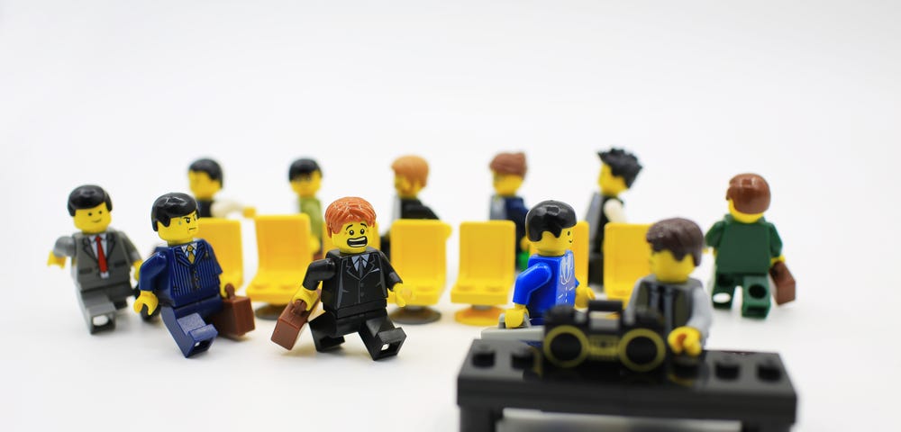 IMAGE: Mini-Lego figures dressed as executives and playing a game of musical chairs