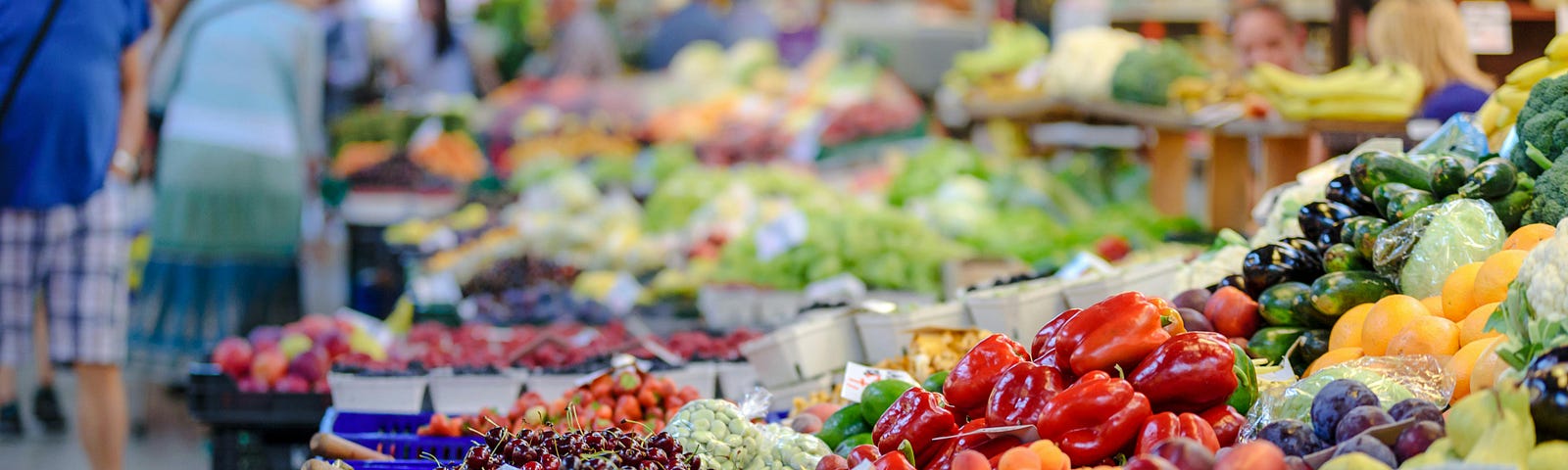 People shopping in a produce aisle.