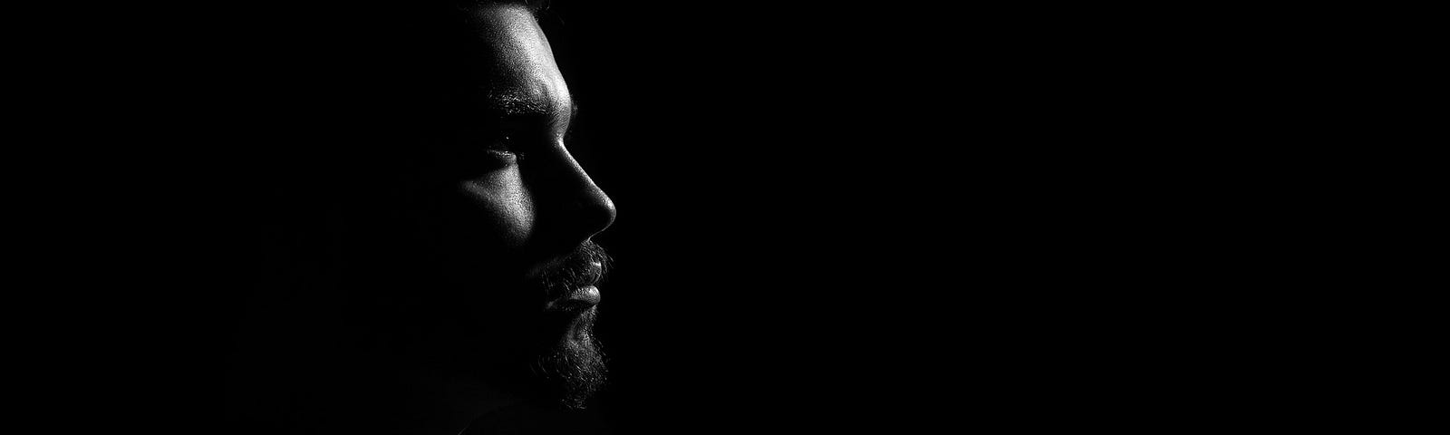 Side profile of a man in a dark background