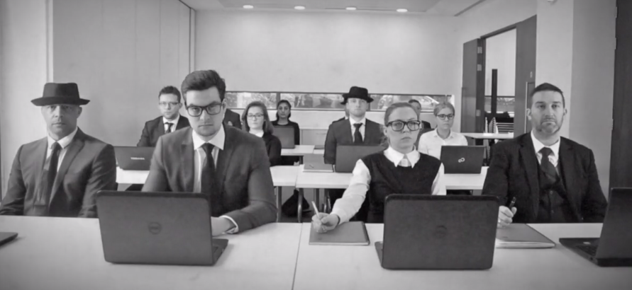 A tongue-in-cheek image of a office workers sat in a uniformed row looking unenthused.
