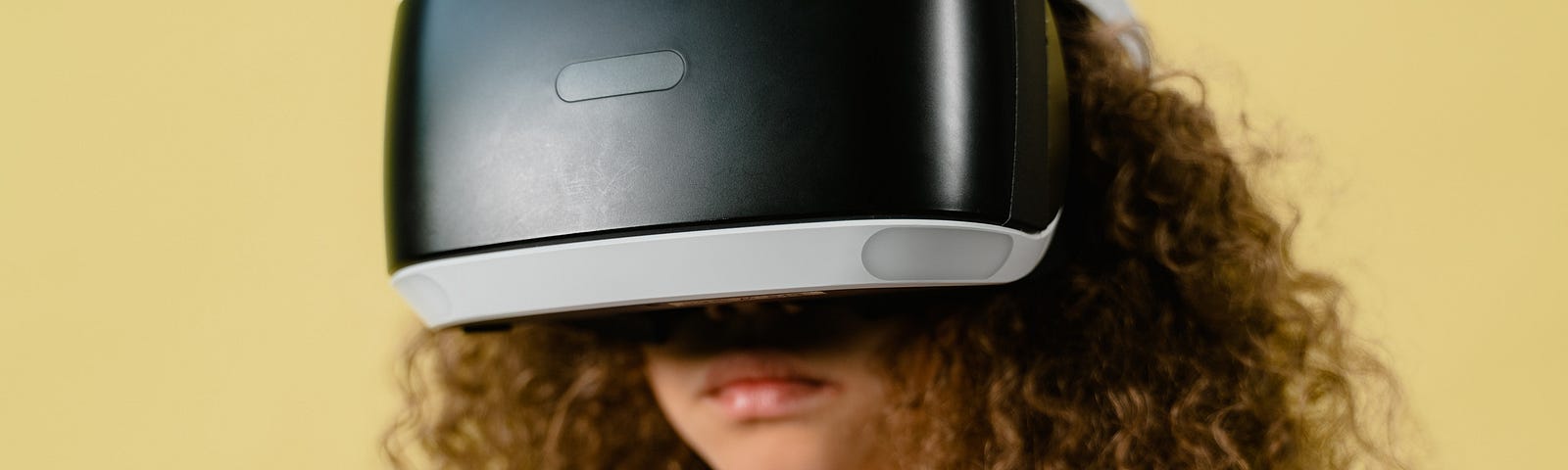 a young girl with curly hair wearing a VR headset