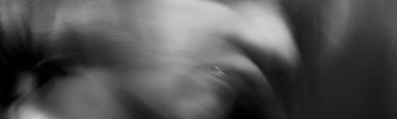 Abstract, black and white image of a blurred face.