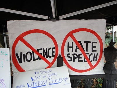 signs protesting against violence and hate speech.