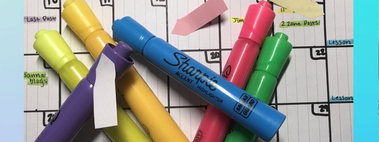 Highlighters strewn across a handmade July calendar with post-it notes.