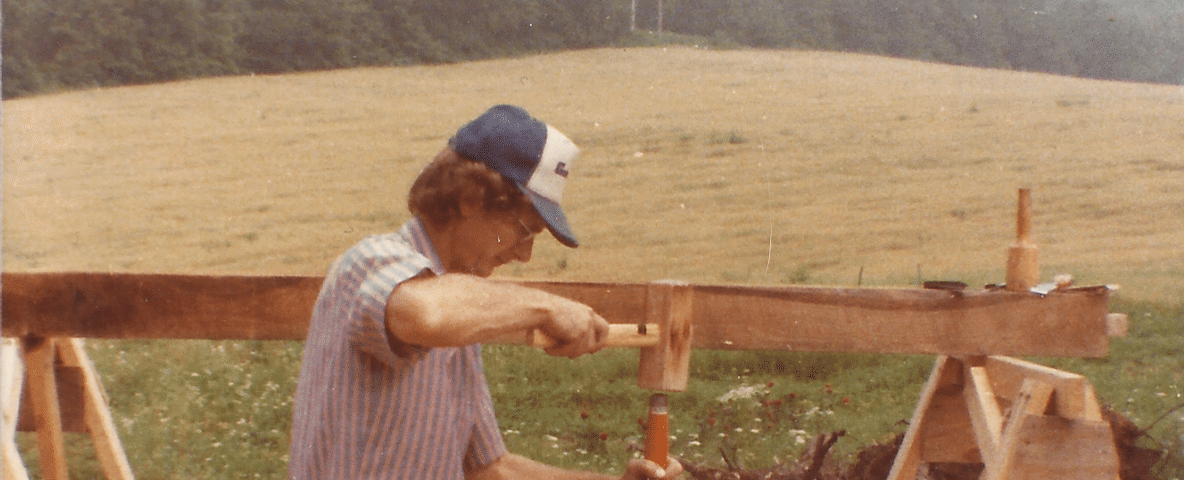 My father carving a beam while building our house
