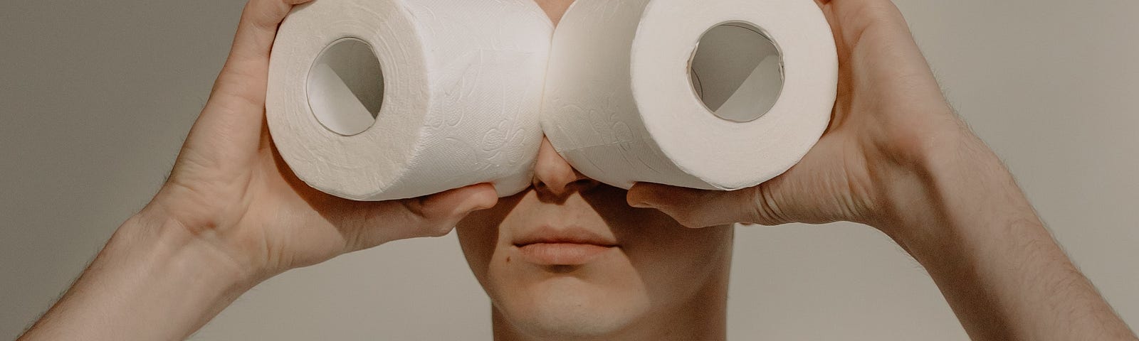 Seinfeld. A man looking through 2 roles of toilet paper.