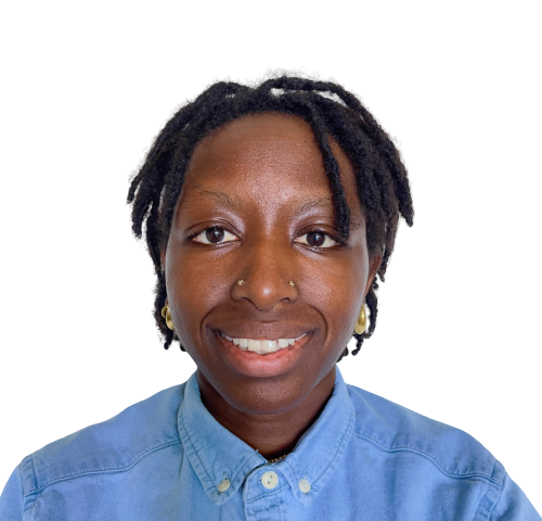 Photo of Precious (she/they), a dark-skinned Black woman, from the shoulders up. She is looking straight into the camera with an open smile. She has ear-length black dreadlocks, gold studs in each nostril, and gold earrings. She is wearing a blue denim button shirt, with all buttons fastened.