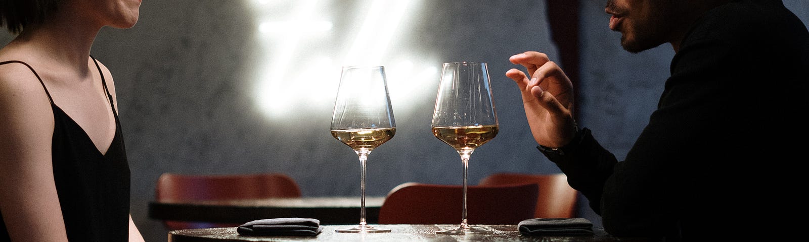 man articulating with his hands to a date over wine