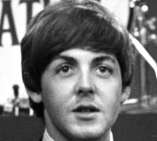 a black and white head shot of Paul McCartney in his early Beatle years