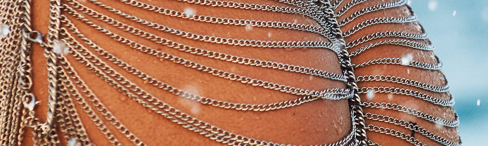 Beautiful chain maille-like jewelry worn on a woman’s butt. Lots of loopy chains over flash.