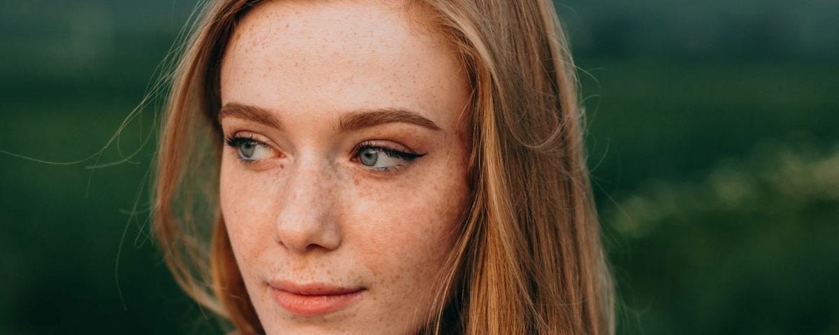 A red haired woman looking pensive