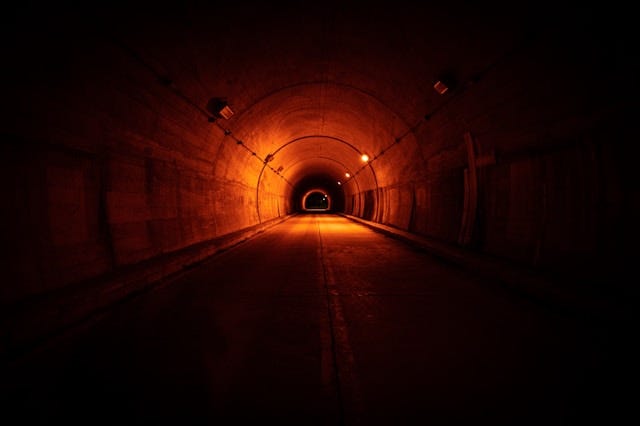 Long dark tunnel with some small amount of light at the end