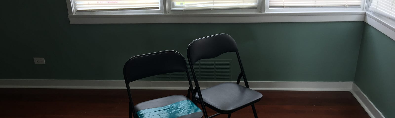 Two folding chairs sit in an empty room in our house.