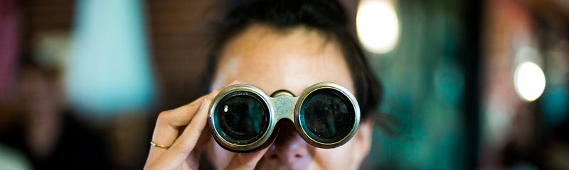A woman looking through binoculars.
