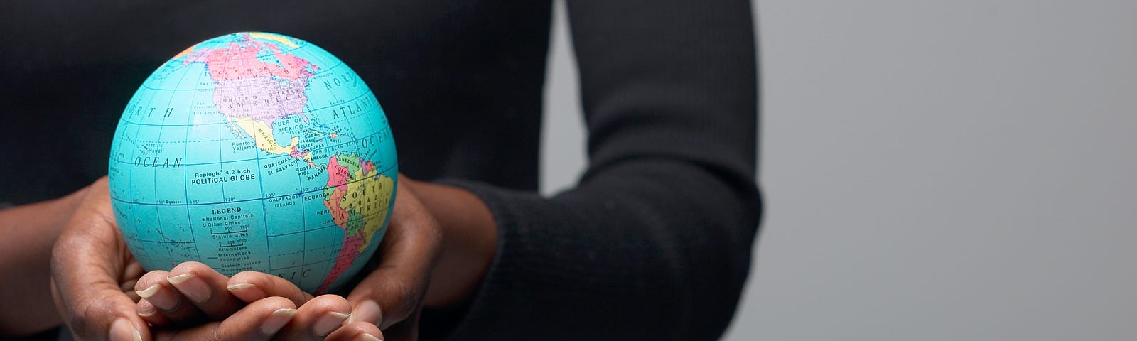 A woman holding a globe in her hands.