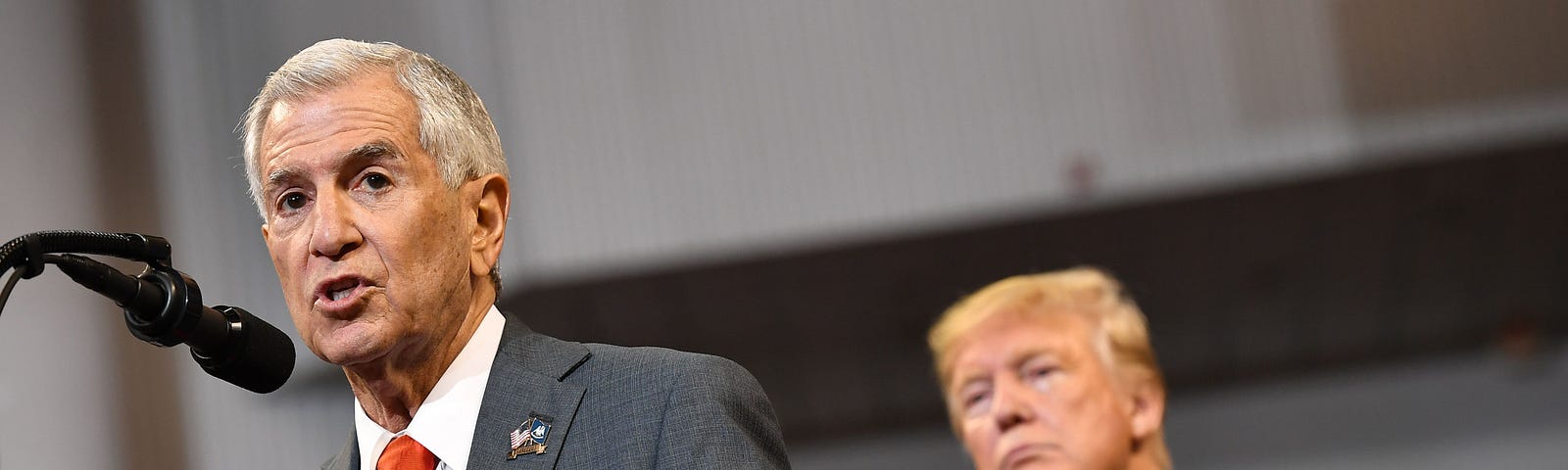 President Donald Trump listens to Louisiana Republican gubernatorial candidate Eddie Rispone speak at a rally.