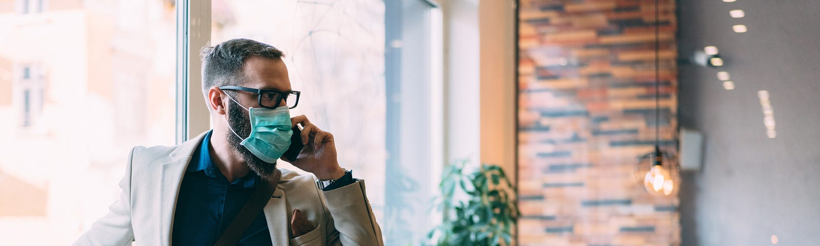 Businessman wearing a face mask walks into his office.