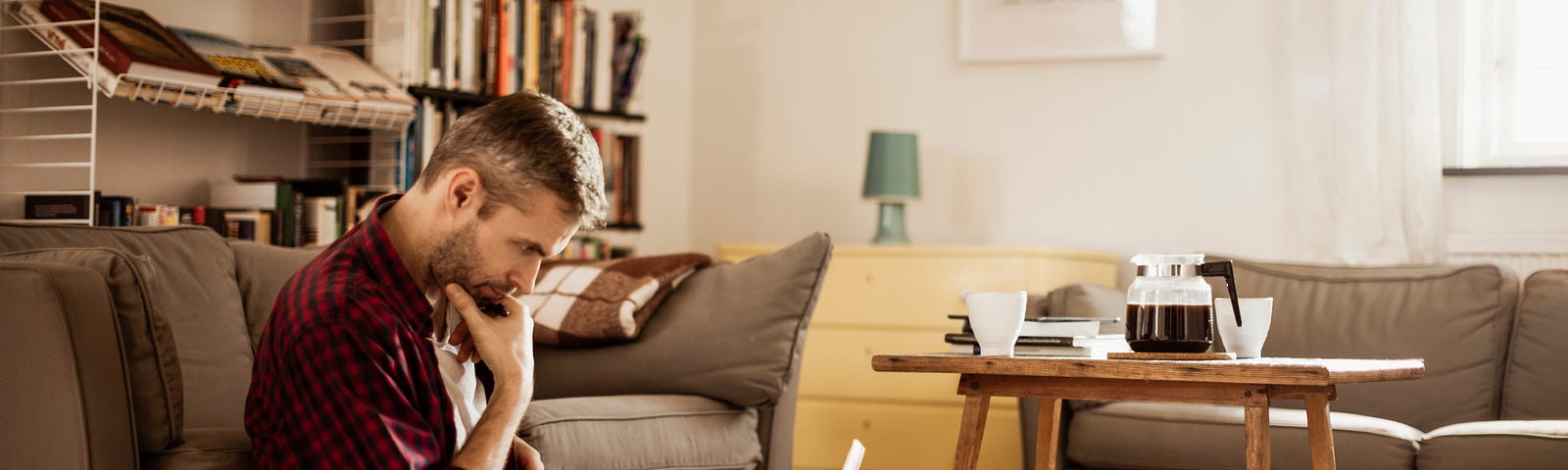 Man ponders in front of his laptop.