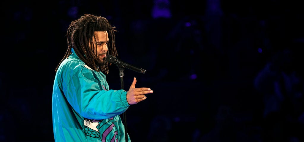 A photo of J. Cole performing on stage.