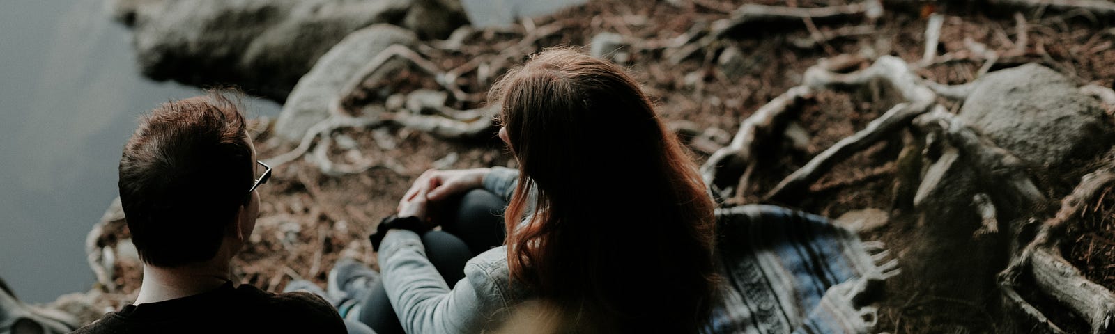 Two people sit on the ground by a body of water, talking. #relationships #dating #communication #date #relationship #talking