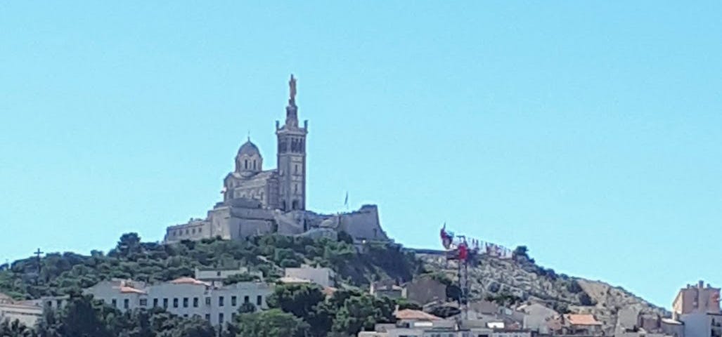 A photograph of the waterfront and a church in Marseille, France.