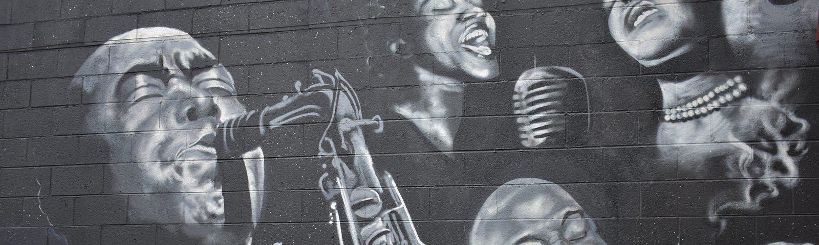 Black and white photo of a mural on the wall of Harlem Renaissance musicians.