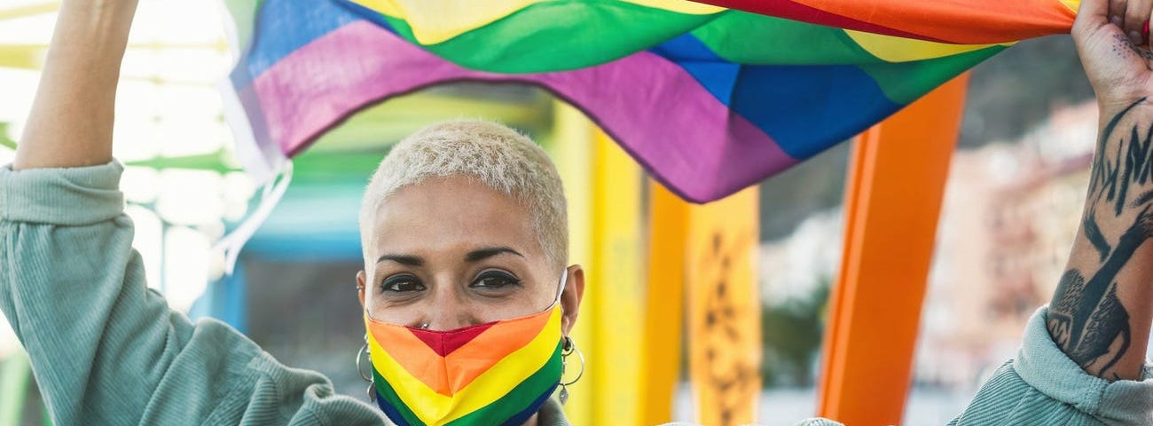 A person holds a rainbow flag.