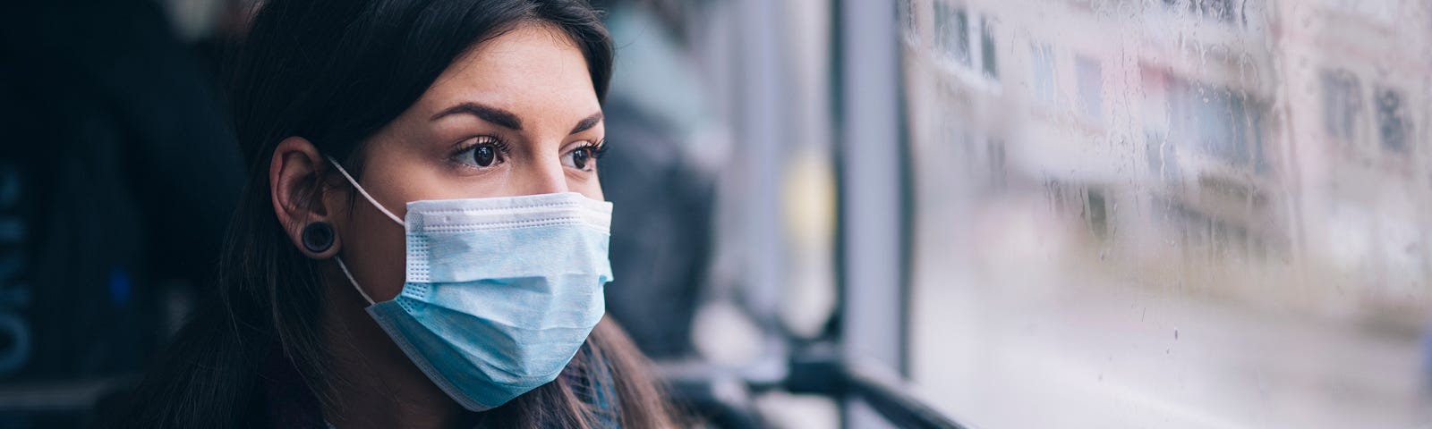 Woman wearing face mask riding the bus.