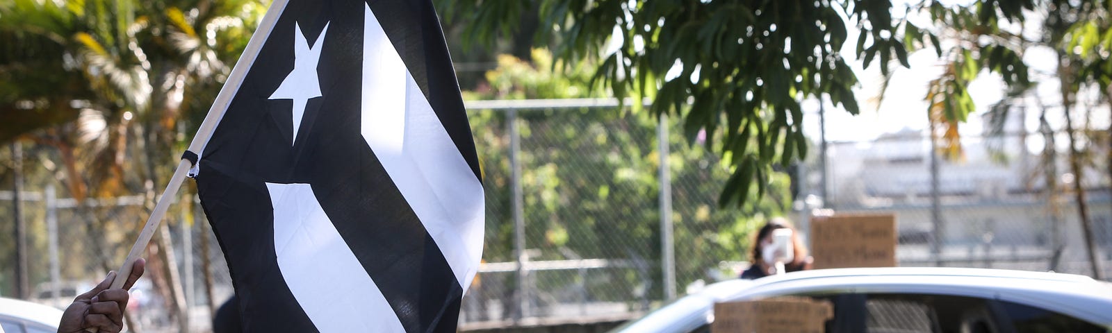 Demonstrators waved a Puerto Rican black flag in a protest calling for more Covid-19 tests to be conducted.