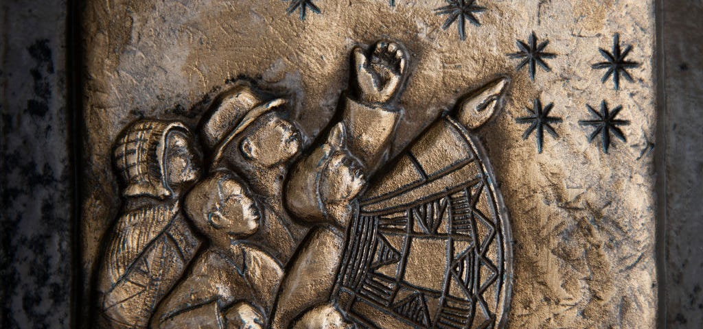 A closeup of a Freedom Trail marker that shows enslaved people guided by stars at night on their way to freedom.