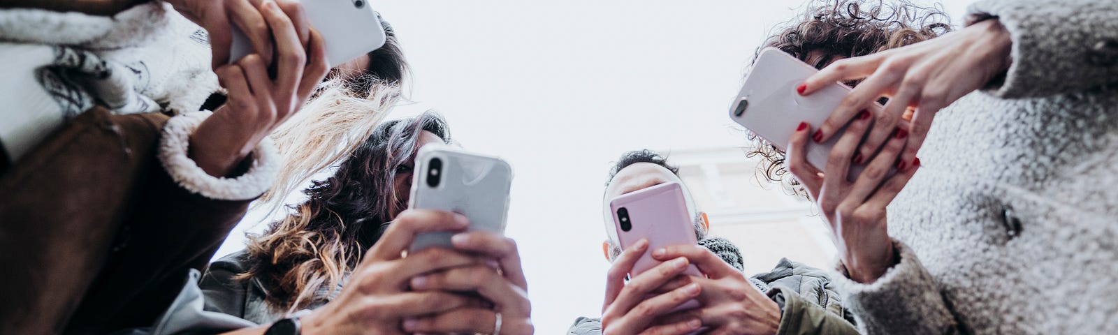 A group of people looking down at their phones.