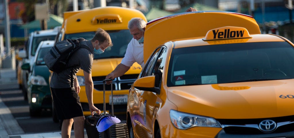 A cab driver helping a passenger load his luggage at LAX.