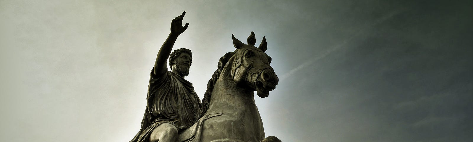 A photo of a sculpture of a man on a horse (presumably a Greek philosopher).