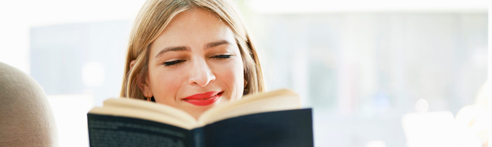 Smiling woman reading a book.