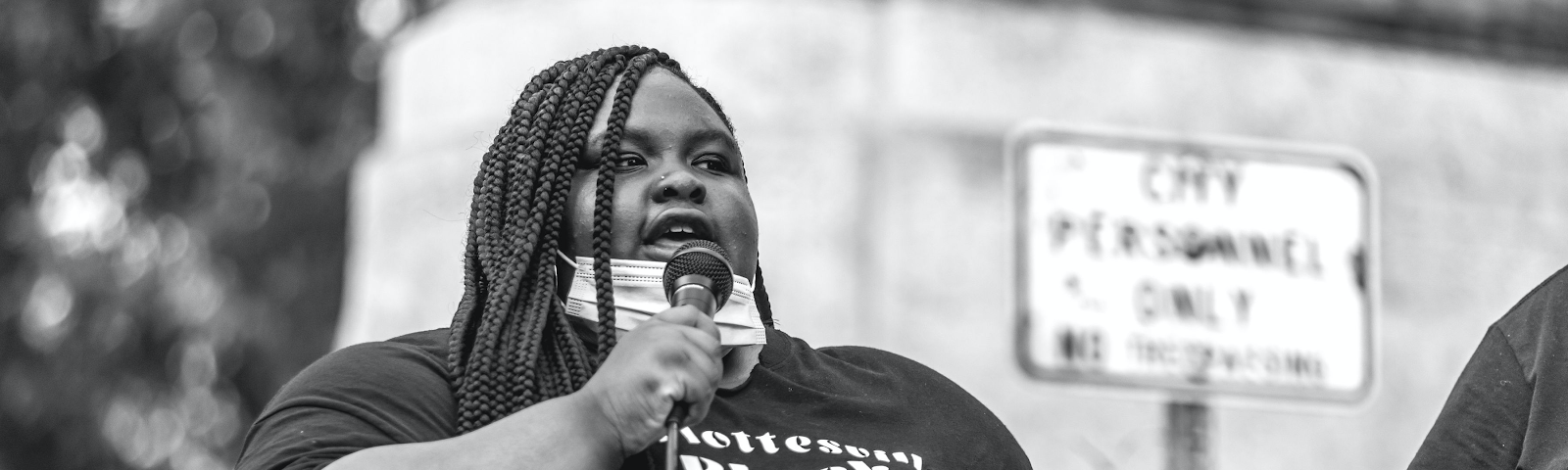 Zyahna Bryant speaking into a micriphone before the Charlottesville statue of Robert E. Lee.