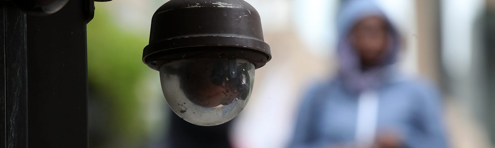 A video surveillance camera hangs from the side of a building in San Francisco, California.