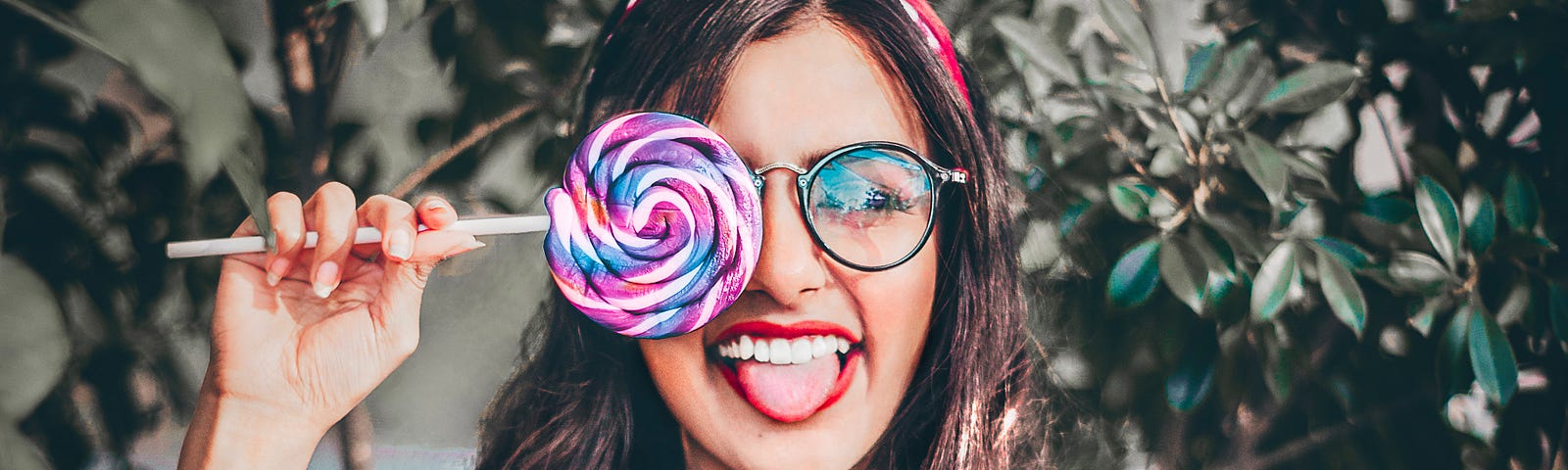 Woman holding lollipop up to face