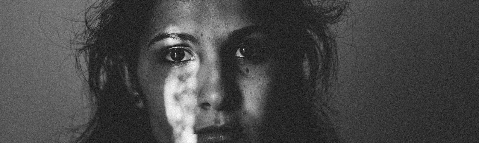 black and white photo of sad looking person with long dark hair