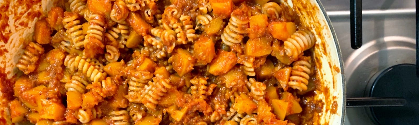 Pasta with winter squash and tomatoes in a Dutch oven.