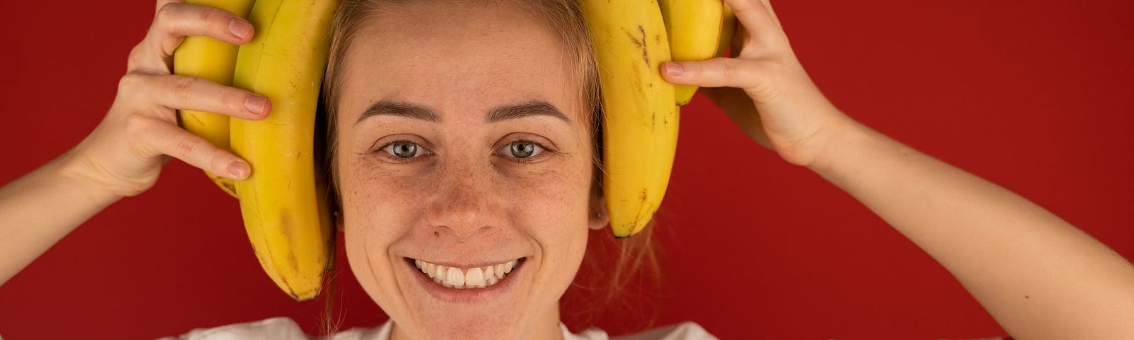 Silly stock photo of woman with a banana bunch on her head.