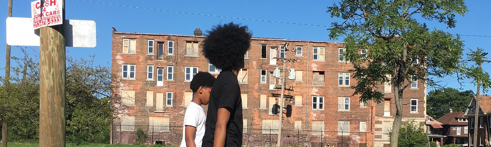 A photo of two Black youths walking down a street in Detroit.