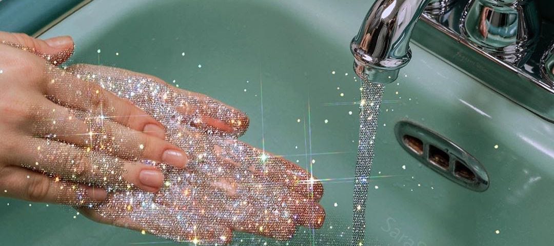 A photo of someone washing their hands in the sink. The water is glittery and sparkly.